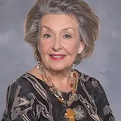 A woman with gray hair wearing a necklace.